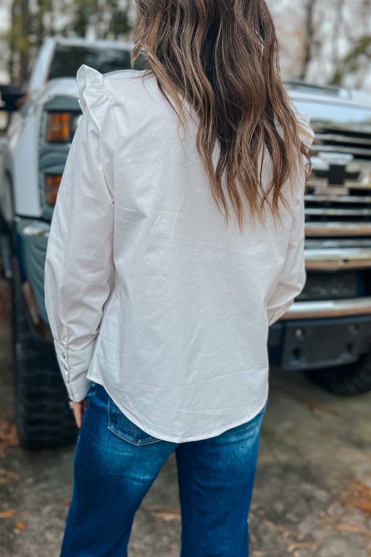 Model wearing white button-up shirt with embroidered collar