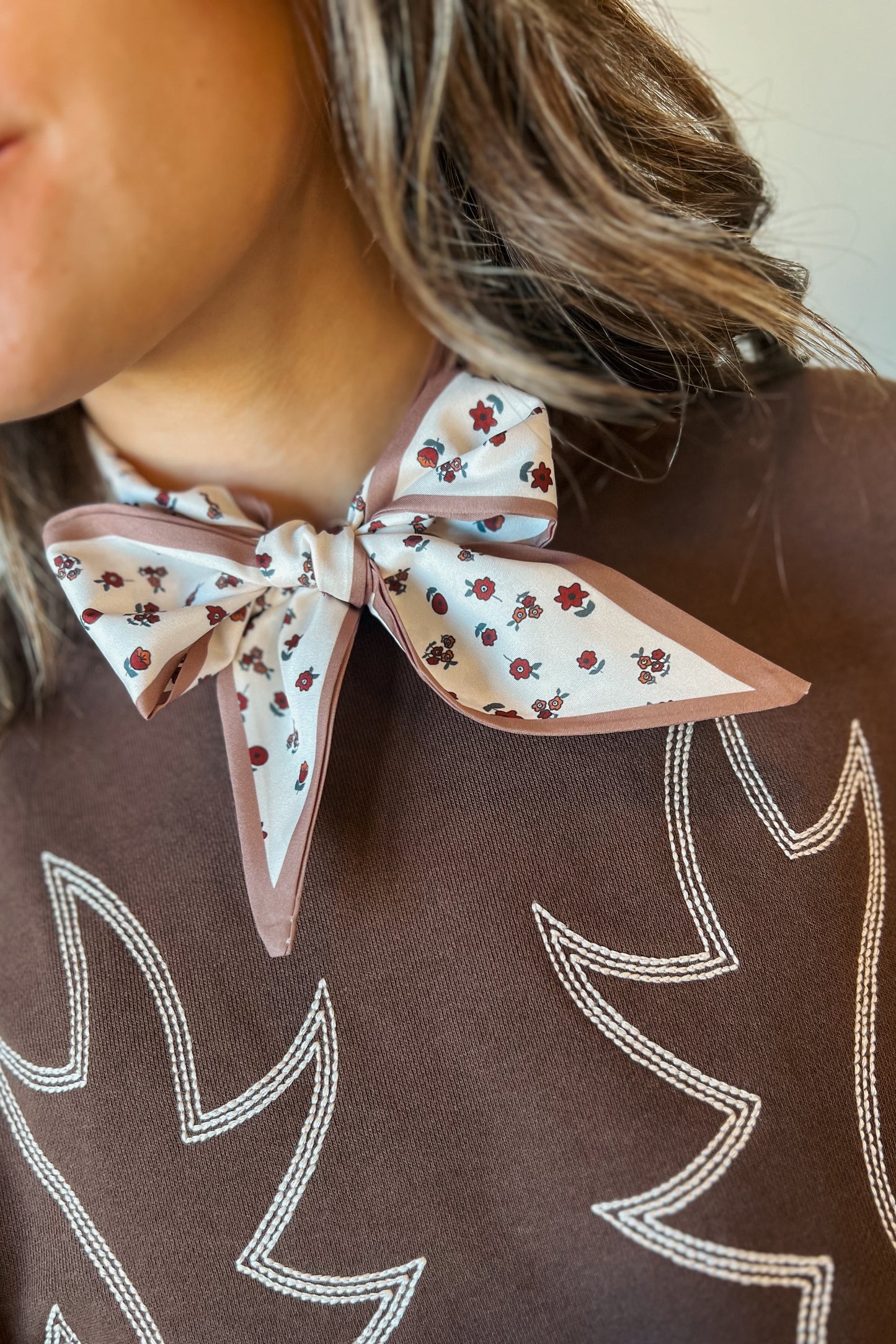Close-up of western floral print bandana styled as a neck bow