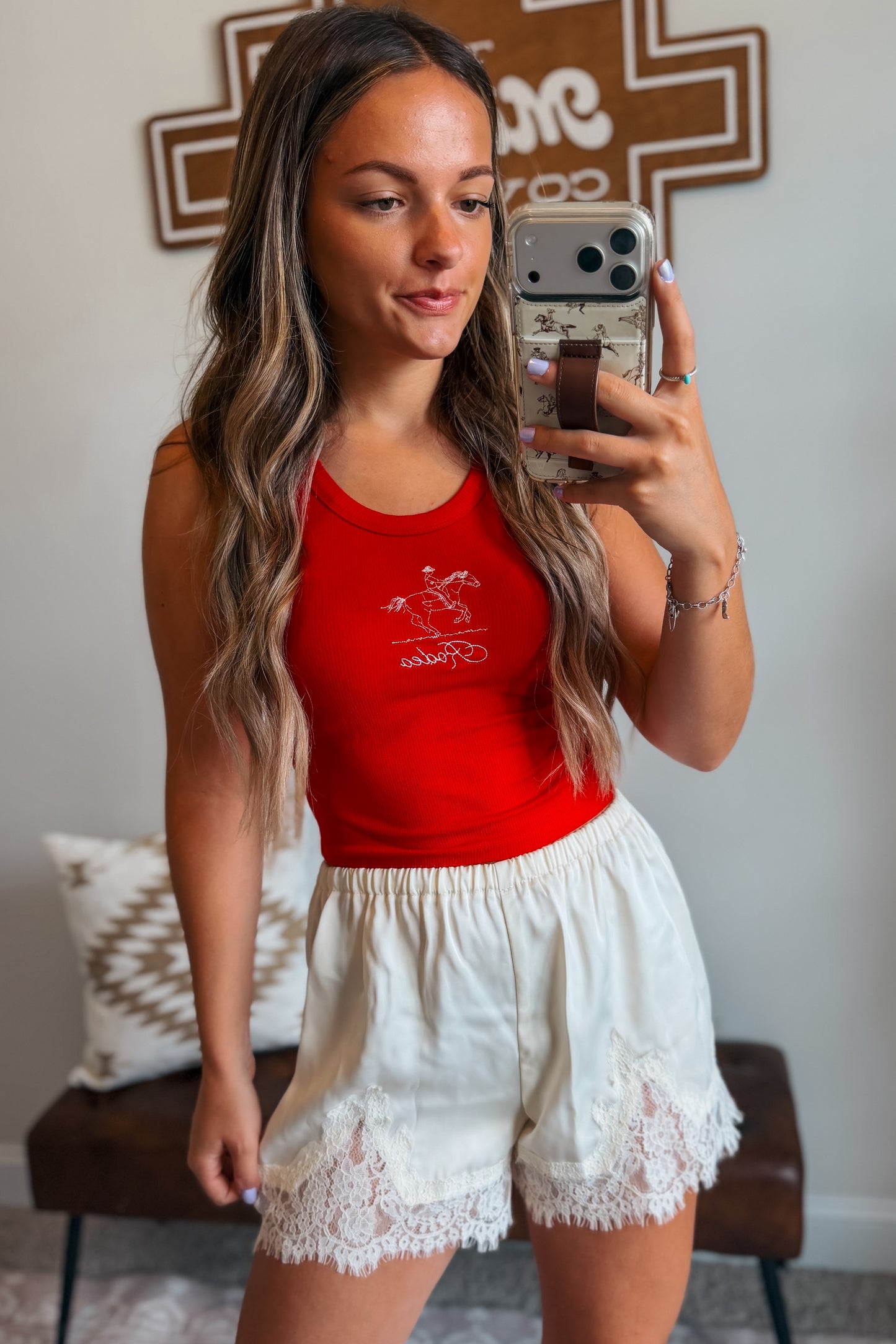 Model wearing cream shorts with lace trim and an elastic waistband styled with a casual outfit.