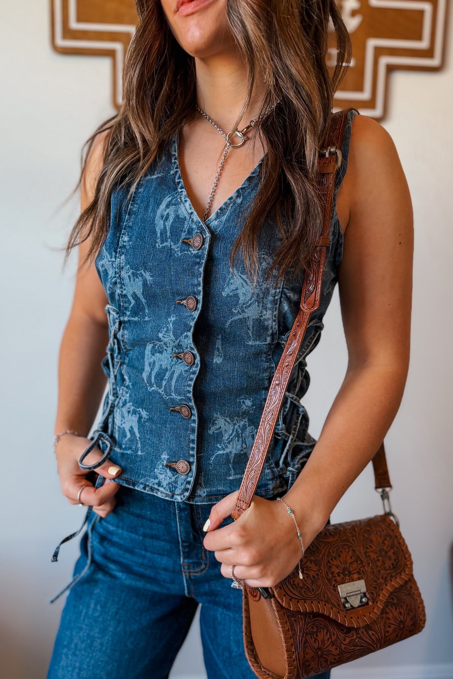 Medium-wash denim vest with a tailored fit and western print detailing throughout, designed with a sleeveless cut and front closure.