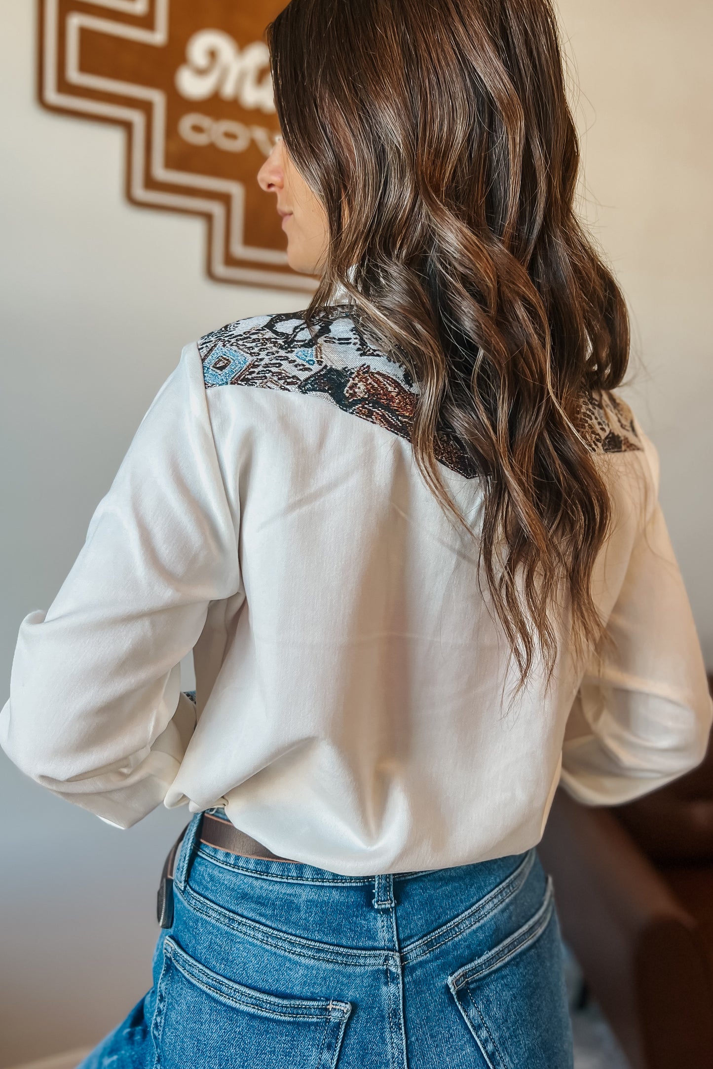 White long sleeve western snap button shirt with contrast southwestern print yoke across the shoulders and matching printed cuffs.