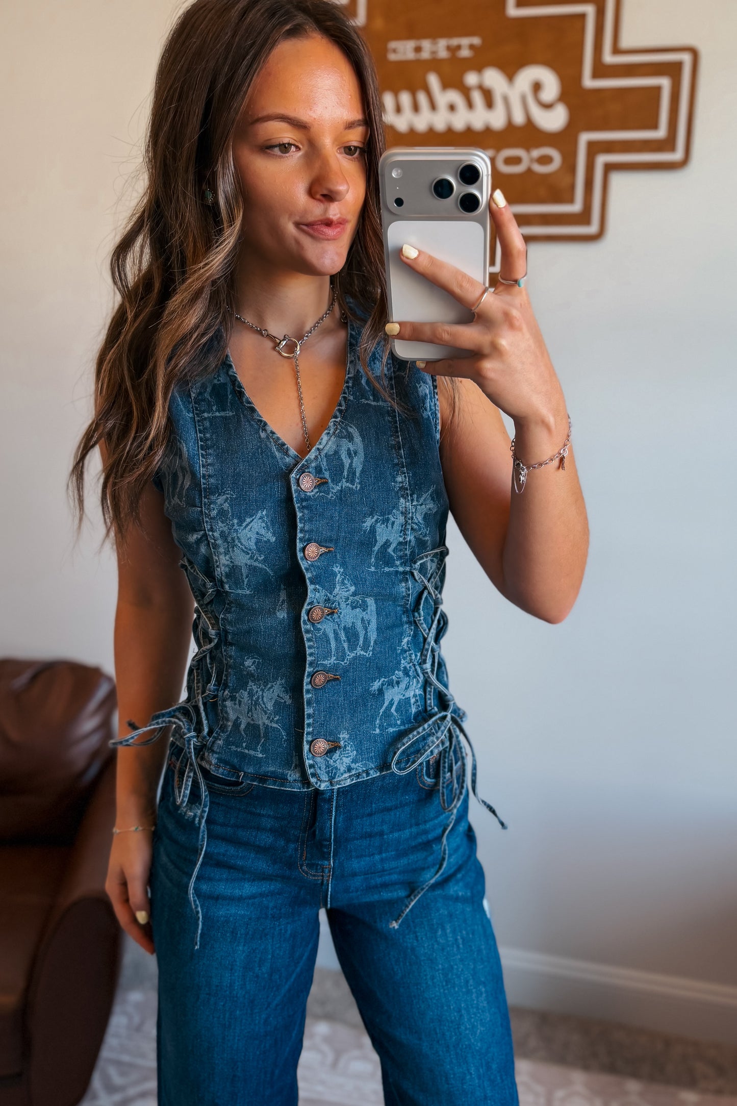 Medium-wash denim vest with a tailored fit and western print detailing throughout, designed with a sleeveless cut and front closure.