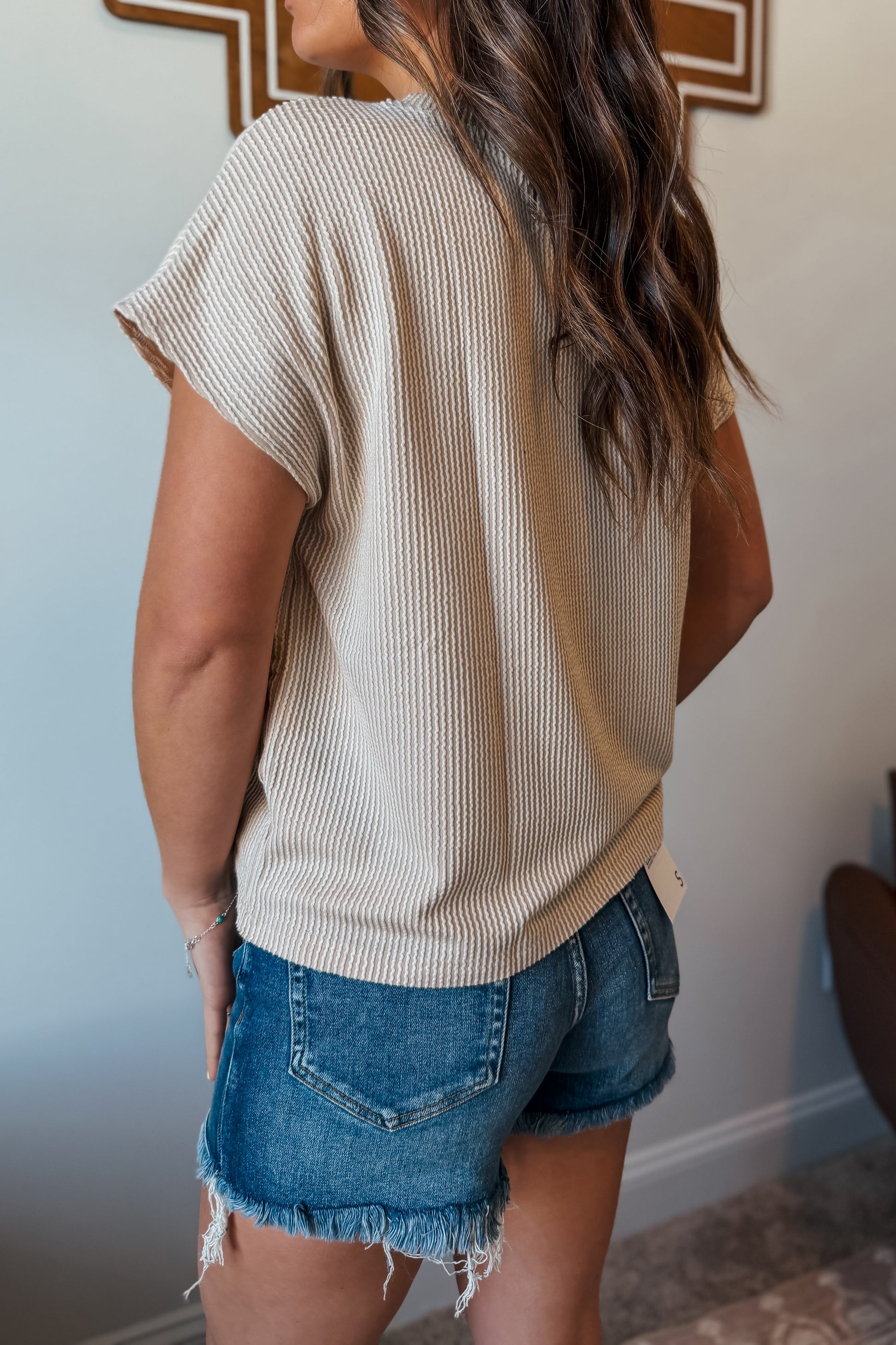 Back view of cream ribbed short sleeve western graphic top with relaxed fit.