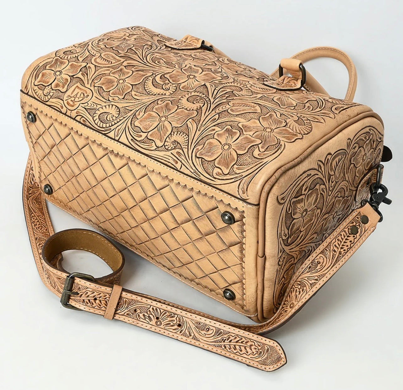 Bottom view of structured leather duffel bag with metal feet.