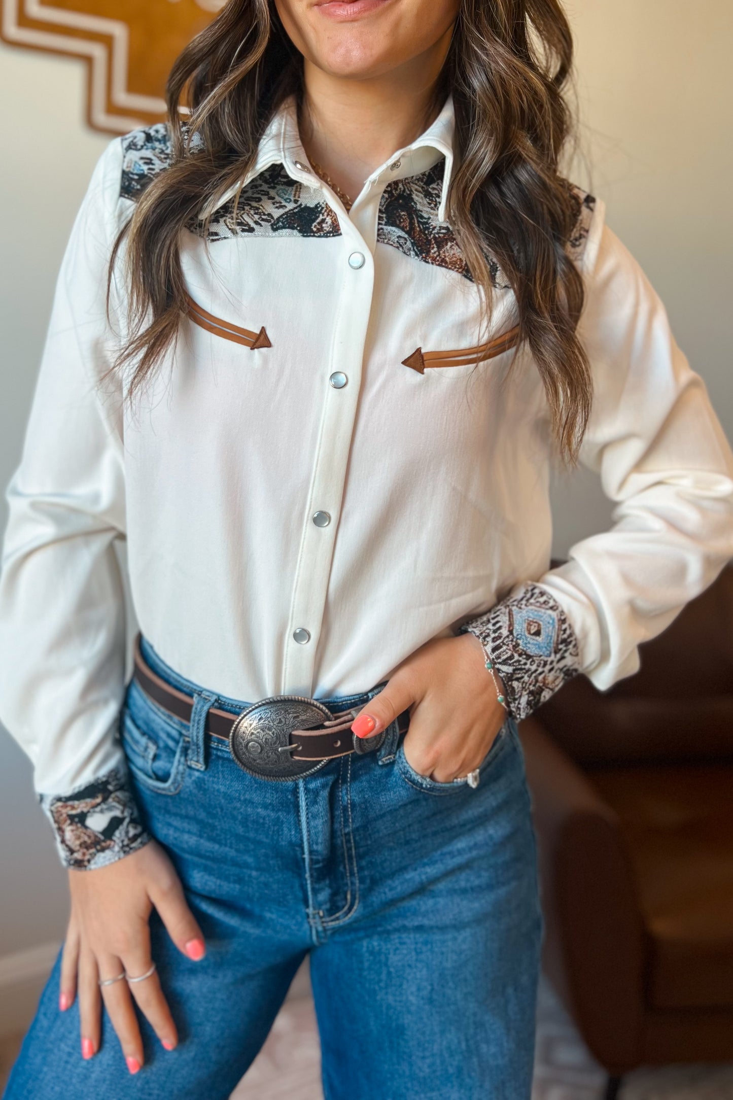 White long sleeve western snap button shirt with contrast southwestern print yoke across the shoulders and matching printed cuffs.