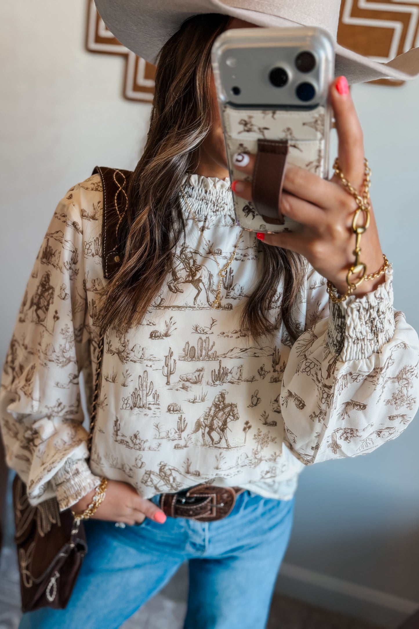 Cream and brown western print long sleeve blouse with ruffle neckline and cuffs.