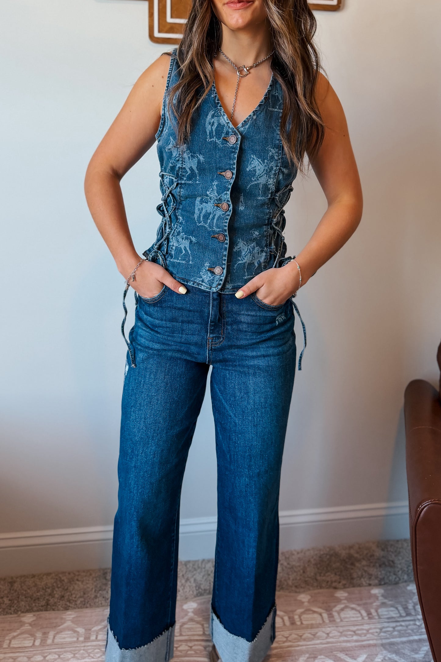 Blue denim vest with a western-themed print, featuring a structured fit and classic sleeveless design.