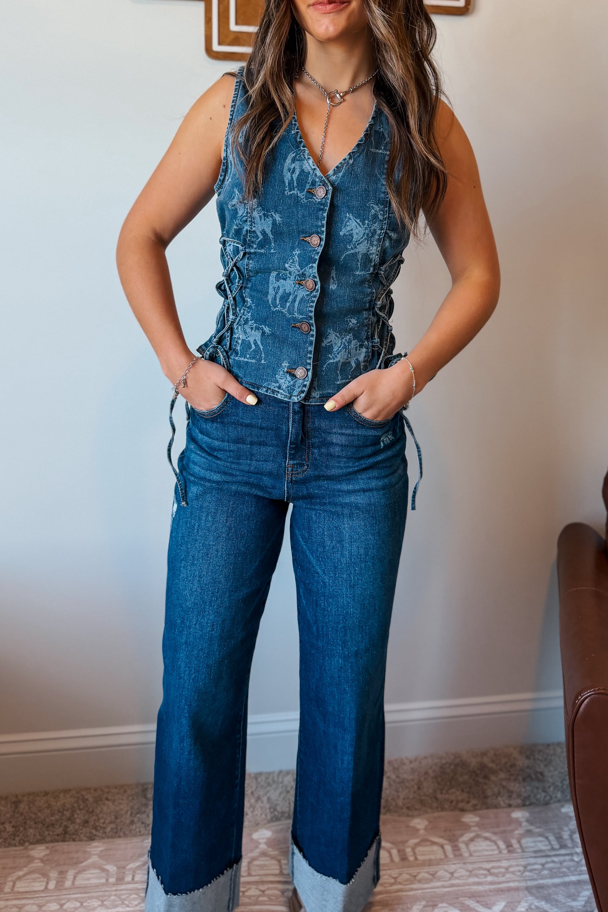 Blue denim vest with a western-themed print, featuring a structured fit and classic sleeveless design.