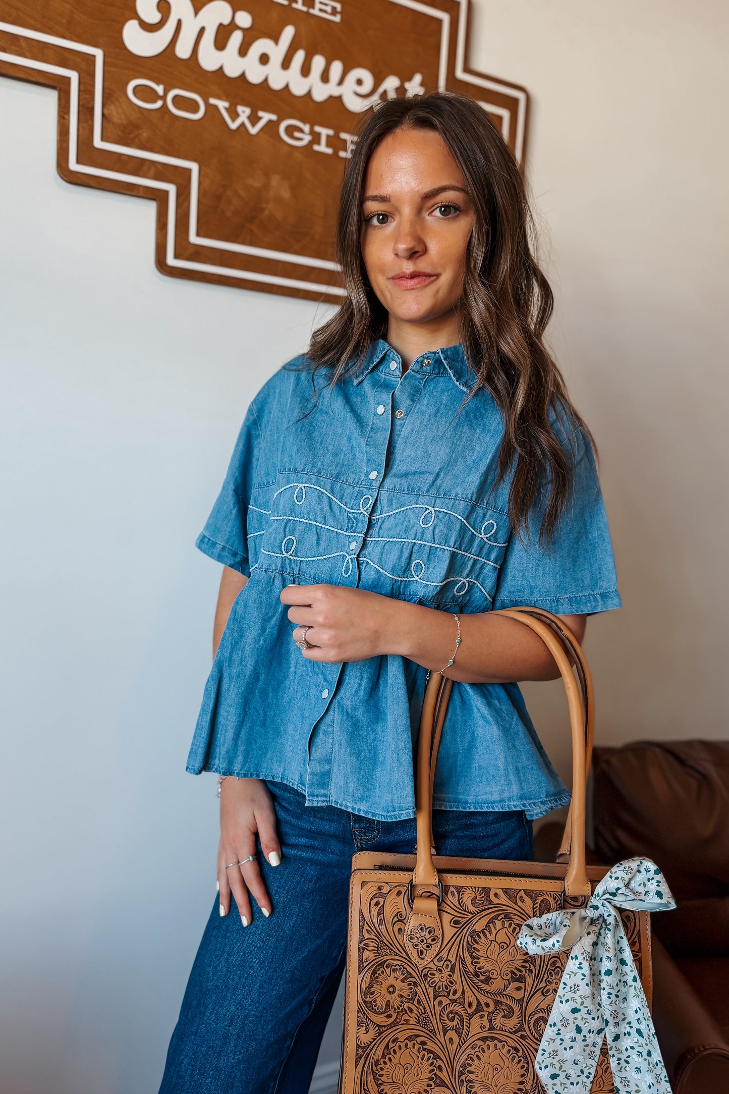 Light wash denim babydoll-style short sleeve top with pearl snap buttons and rope detailing at the front, relaxed fit for casual Western-inspired outfits