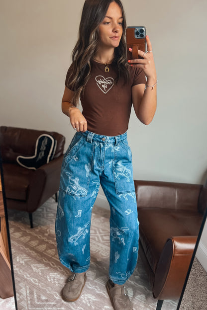 Western-inspired printed denim jeans with cowboy and rodeo motifs