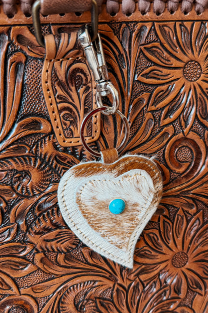 Heart-shaped cowhide keychain with natural brown and white pattern.