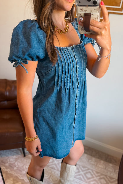 Side view of denim mini dress with square neckline and puff sleeves.
