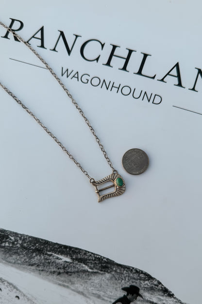 A silver-toned chain necklace with a small pendant featuring a green heart-shaped stone,