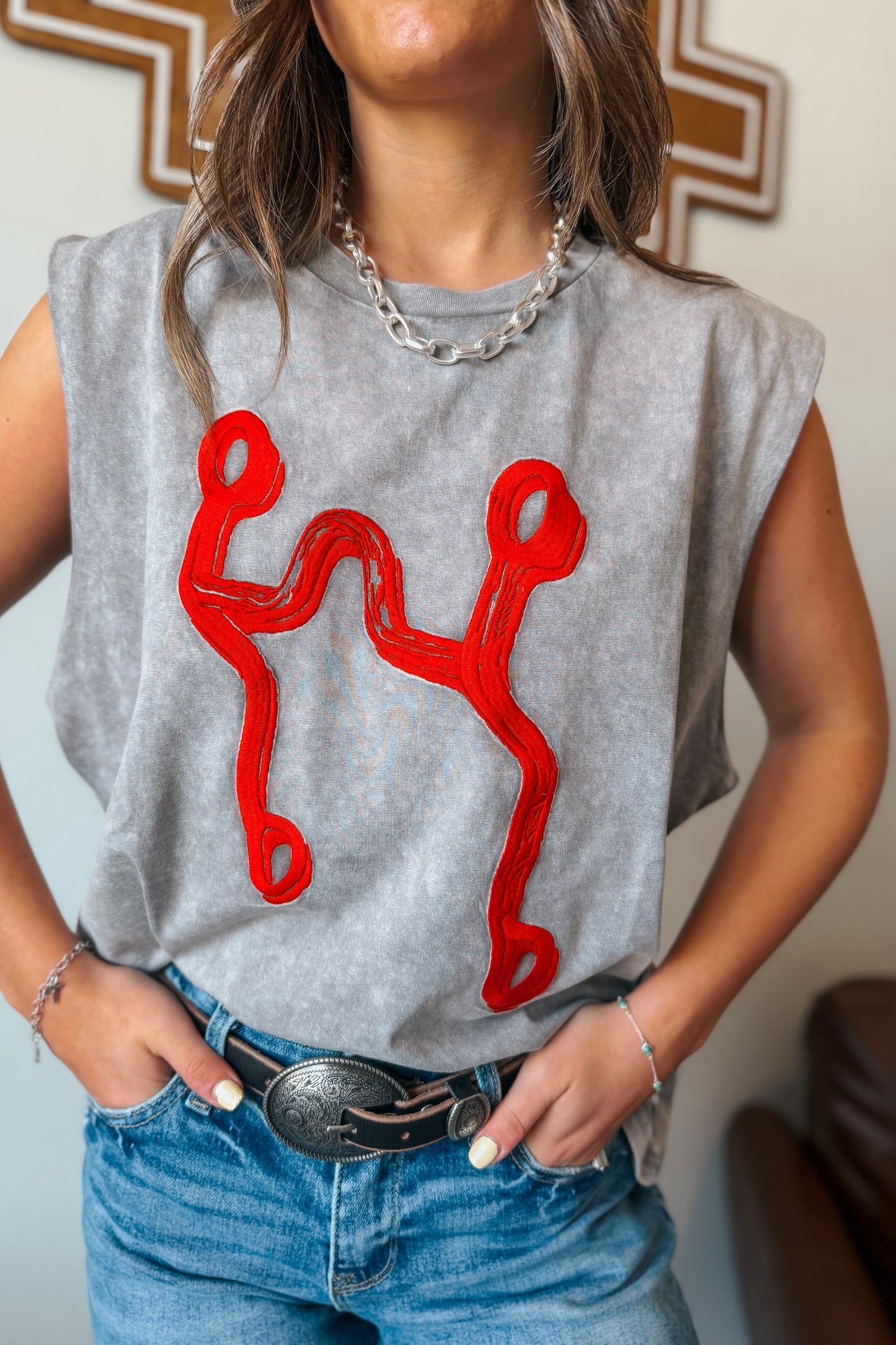 Gray mineral-wash sleeveless muscle tank with red curb bit embroidered on the front.