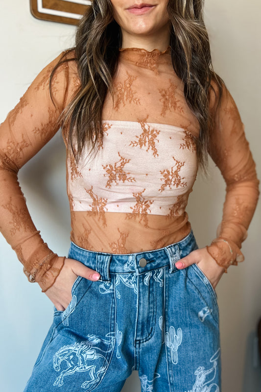 Sheer long-sleeve lace top in warm caramel with floral pattern, featuring a high neckline and lightweight mesh fabric, layered over a light neutral bandea