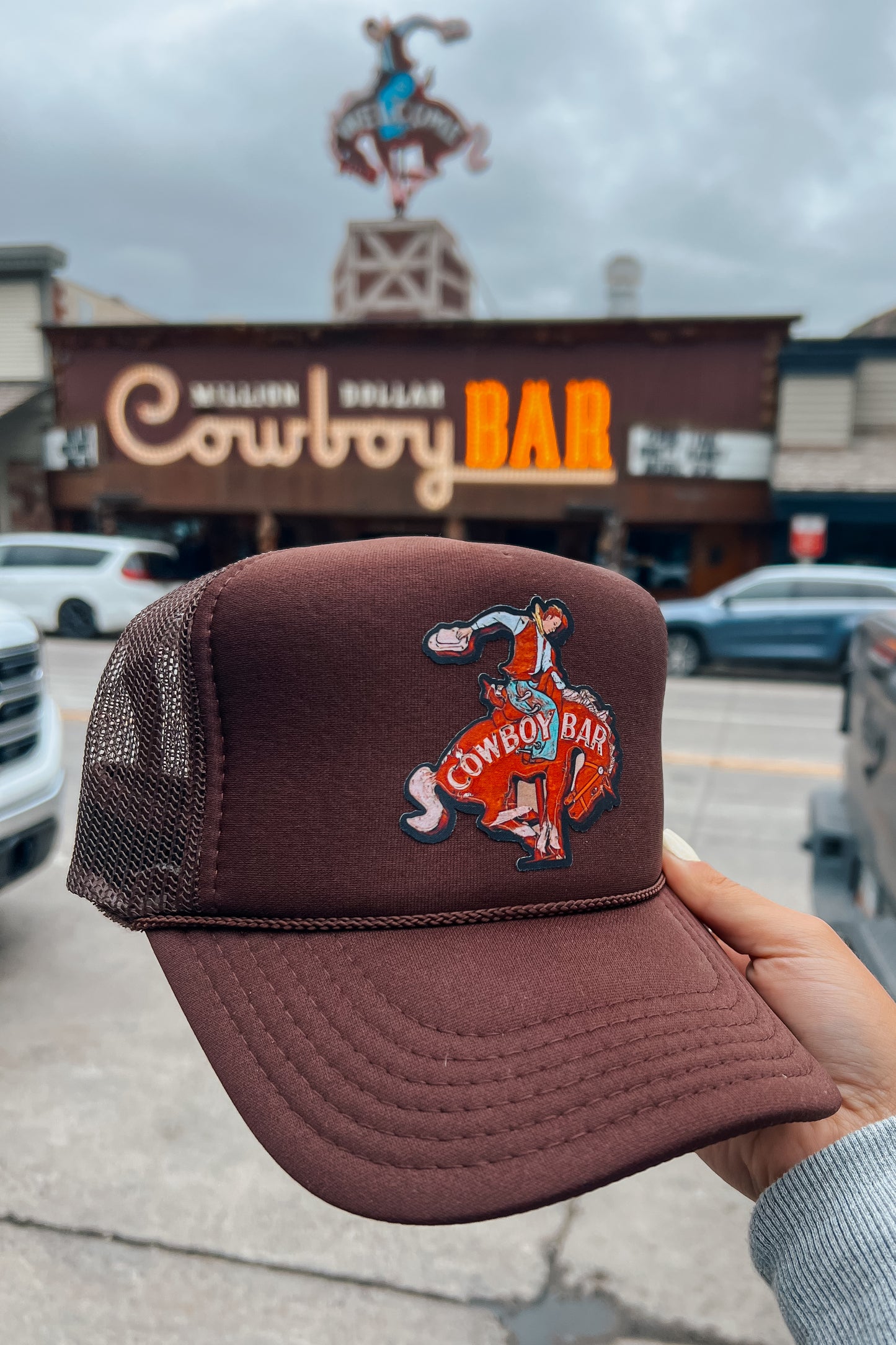 Brown trucker hat featuring a Cowboy Bar