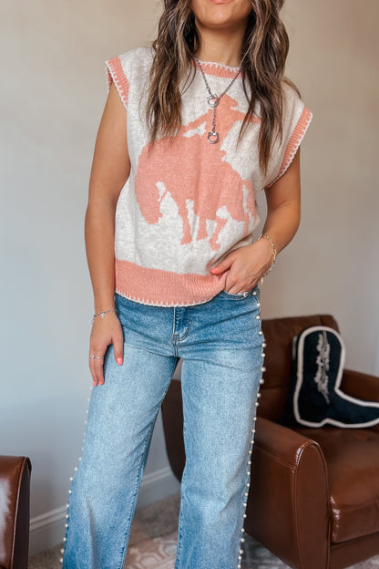 Model wearing western-inspired knit sweater vest with horse design in cream and pink tones