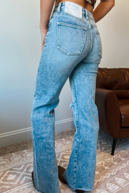 Back view of light wash high-rise flare-leg jeans with classic back pockets.