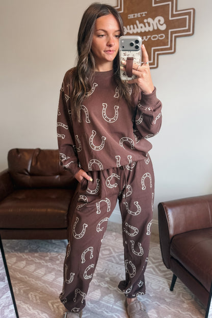 Brown two-piece jogger set with white horseshoe pattern, including long-sleeve sweatshirt and jogger-style pants.
