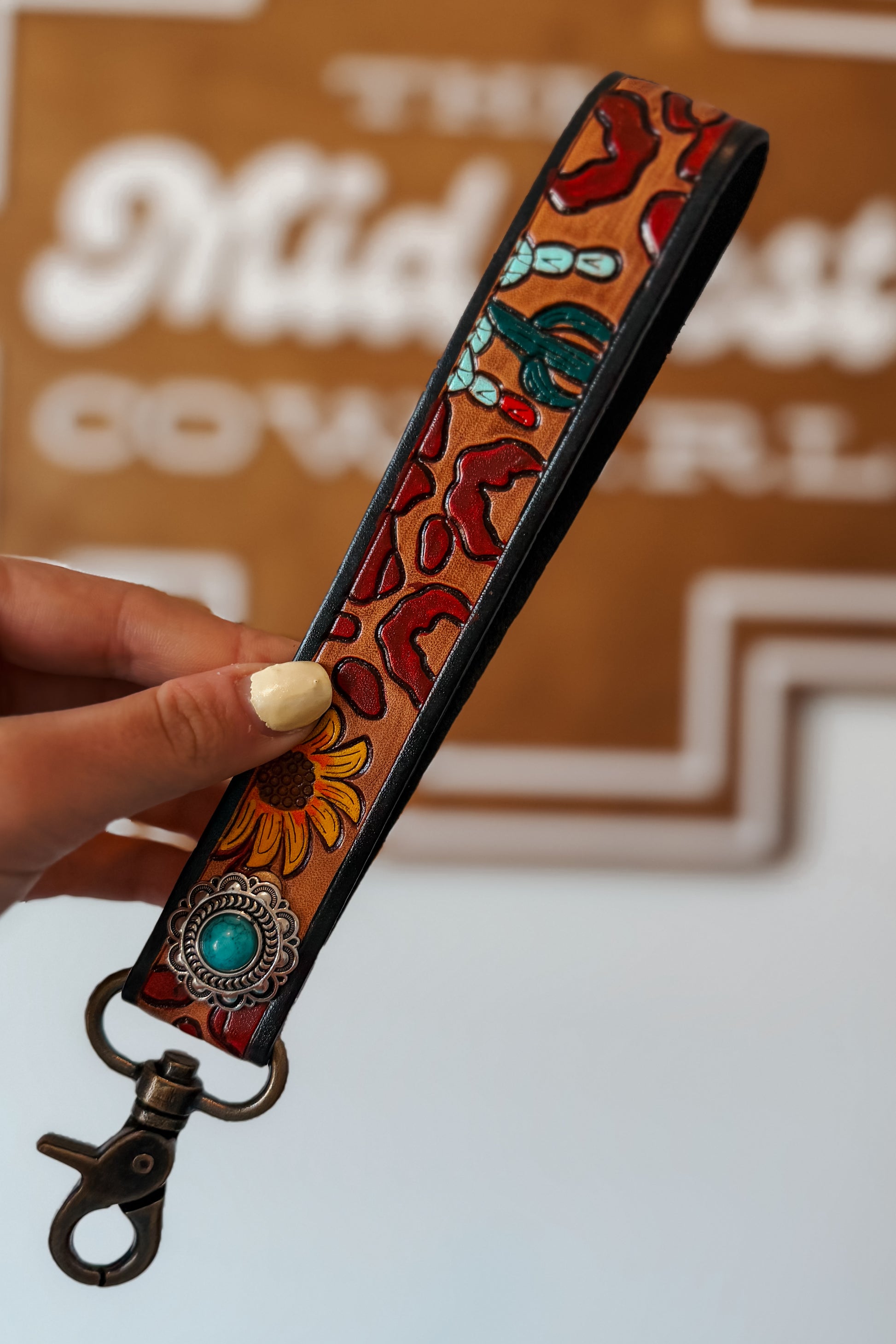 Western leather keychain wristlet with embroidered leopard, sunflower, and cactus design.