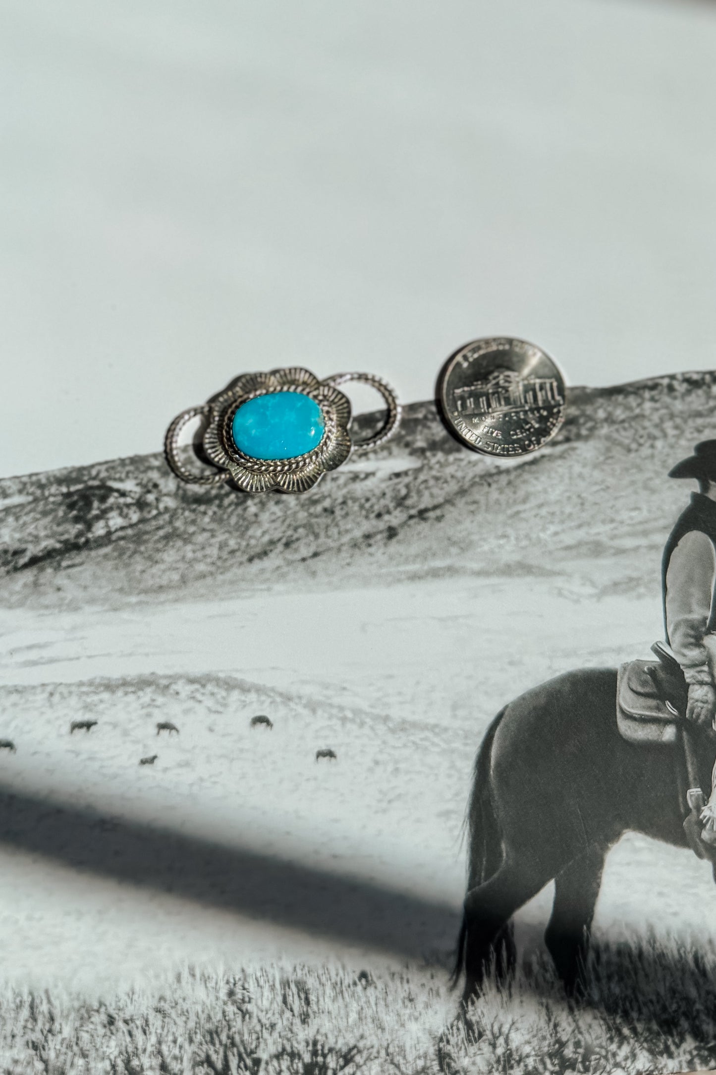 A silver-toned ring with a bright turquoise oval stone. 