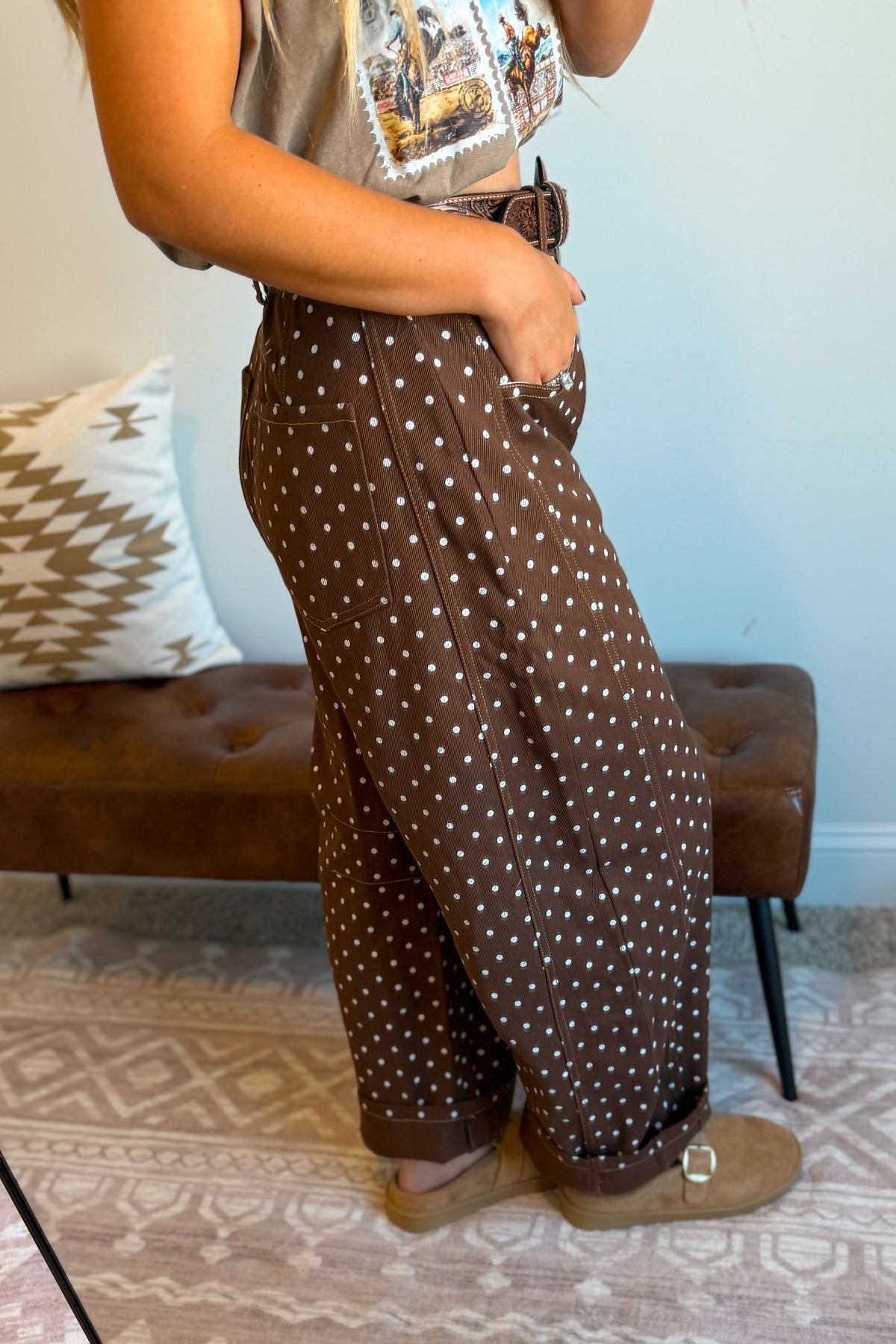 A person wearing brown wide-leg pants with a white polka dot pattern,