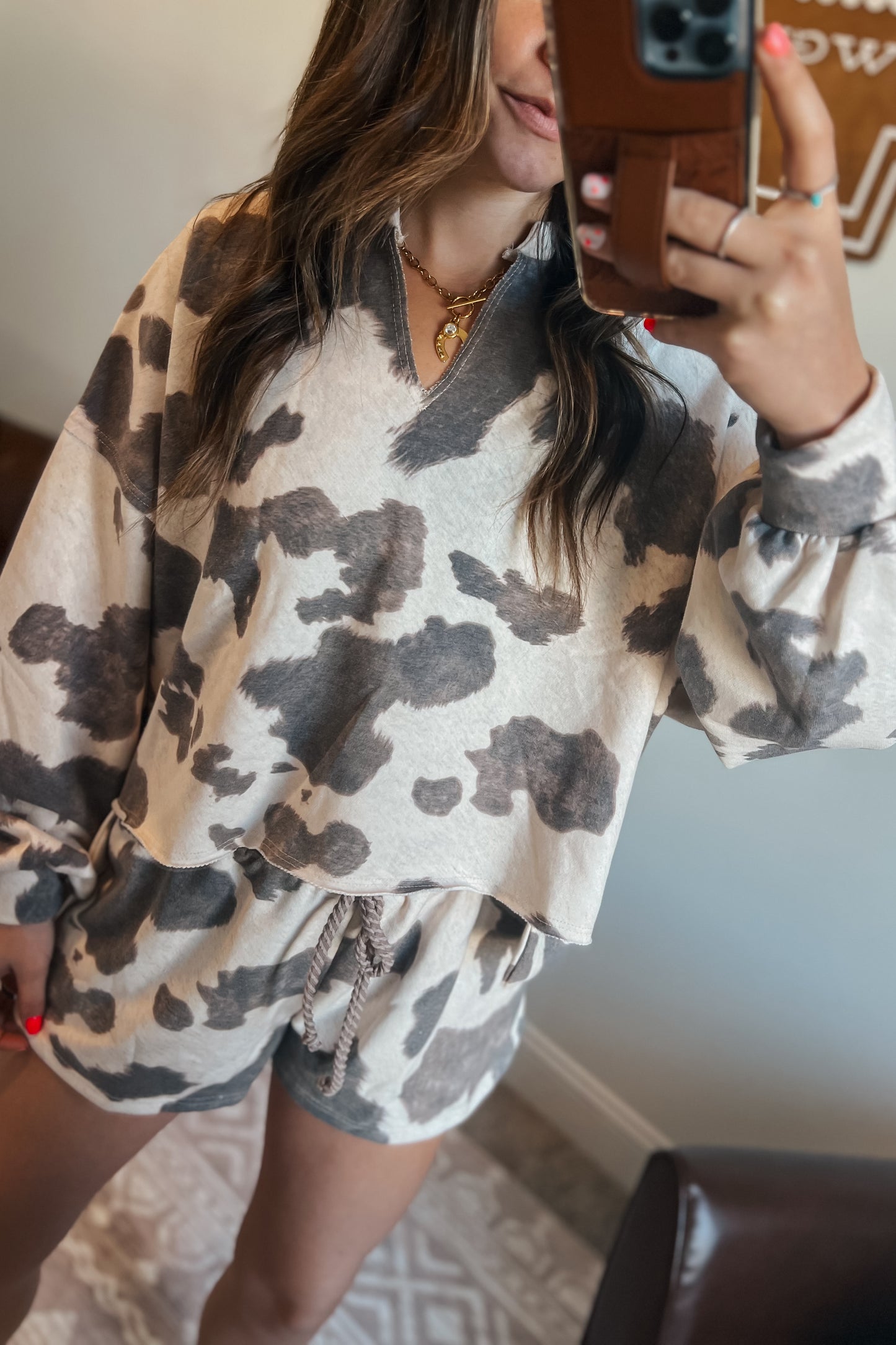 Gray and cream cow print lounge set featuring a long sleeve V-neck top and matching drawstring shorts