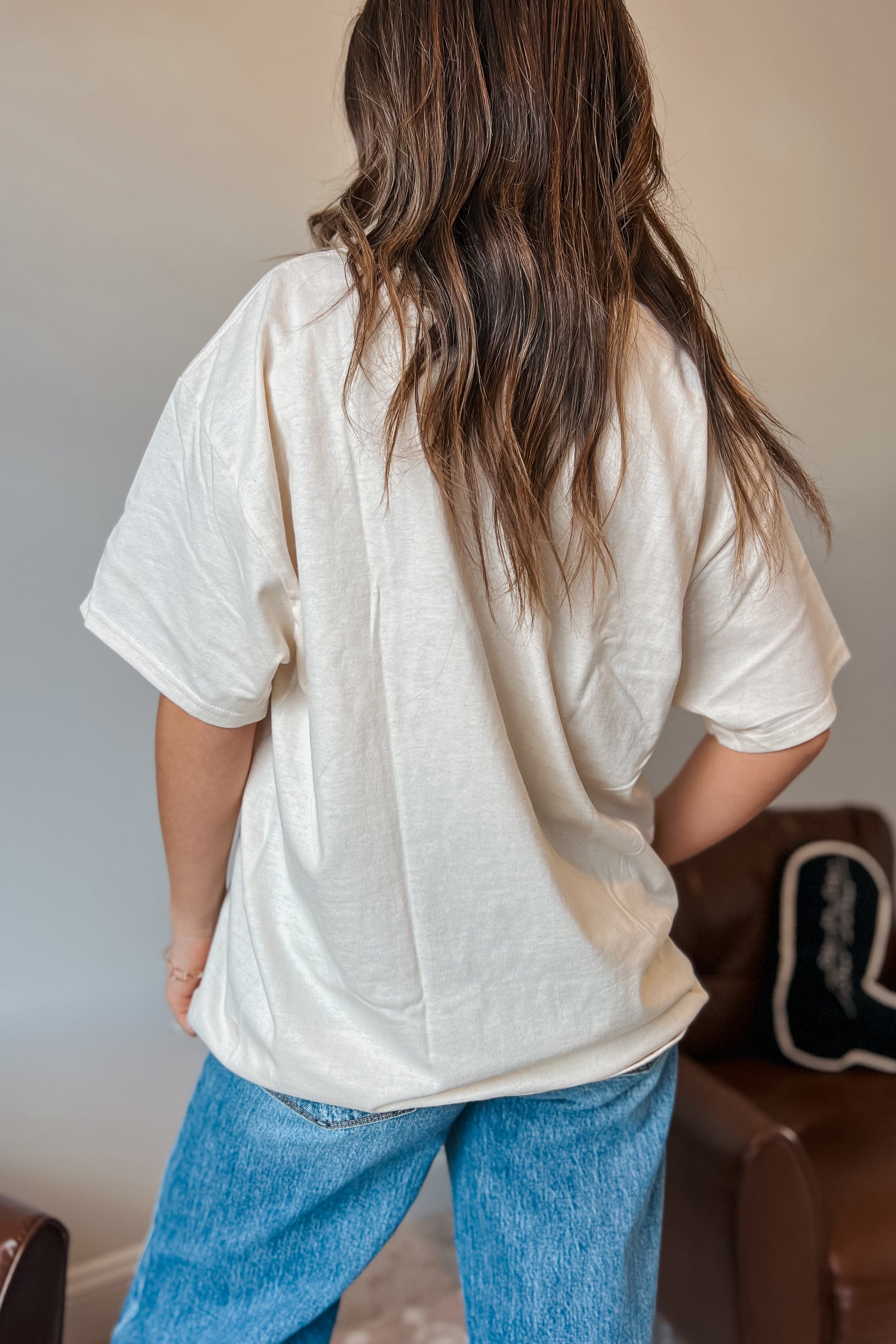 Back view of oversized western graphic t-shirt in cream color