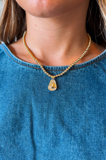 Gold cowboy hat charm necklace with a polished Western-style hat pendant suspended from a delicate gold chain