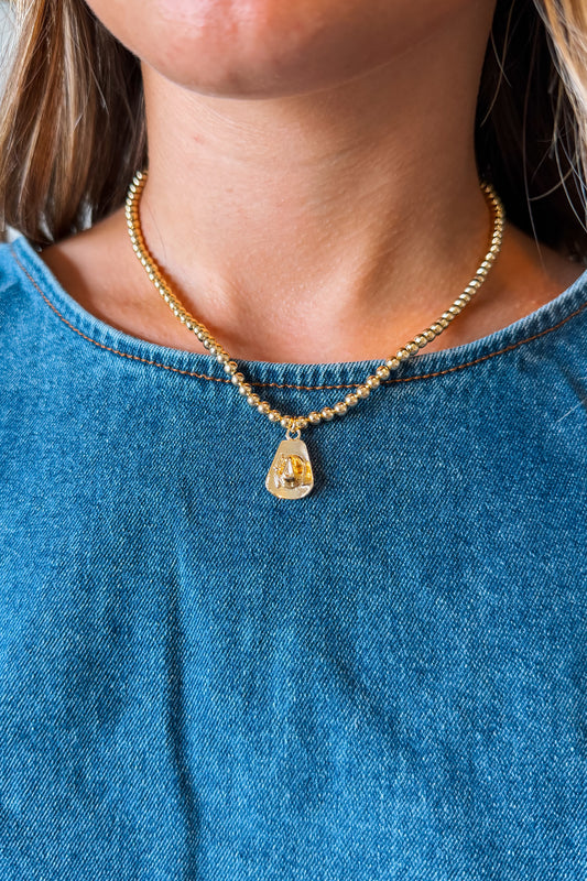 Gold cowboy hat charm necklace with a polished Western-style hat pendant suspended from a delicate gold chain