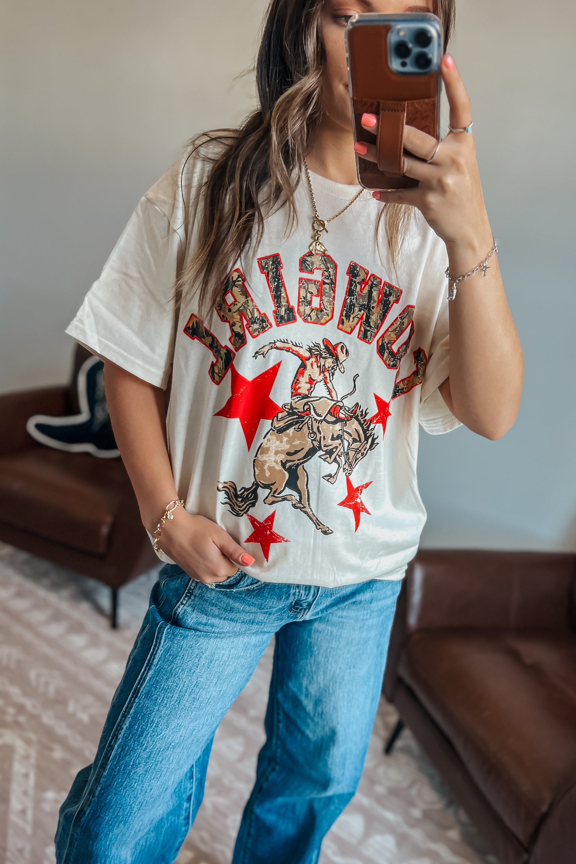 Model wearing oversized camouflage graphic t-shirt with cowgirl design