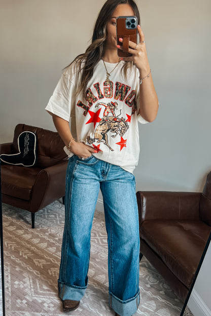 Model wearing oversized camouflage graphic t-shirt with cowgirl design