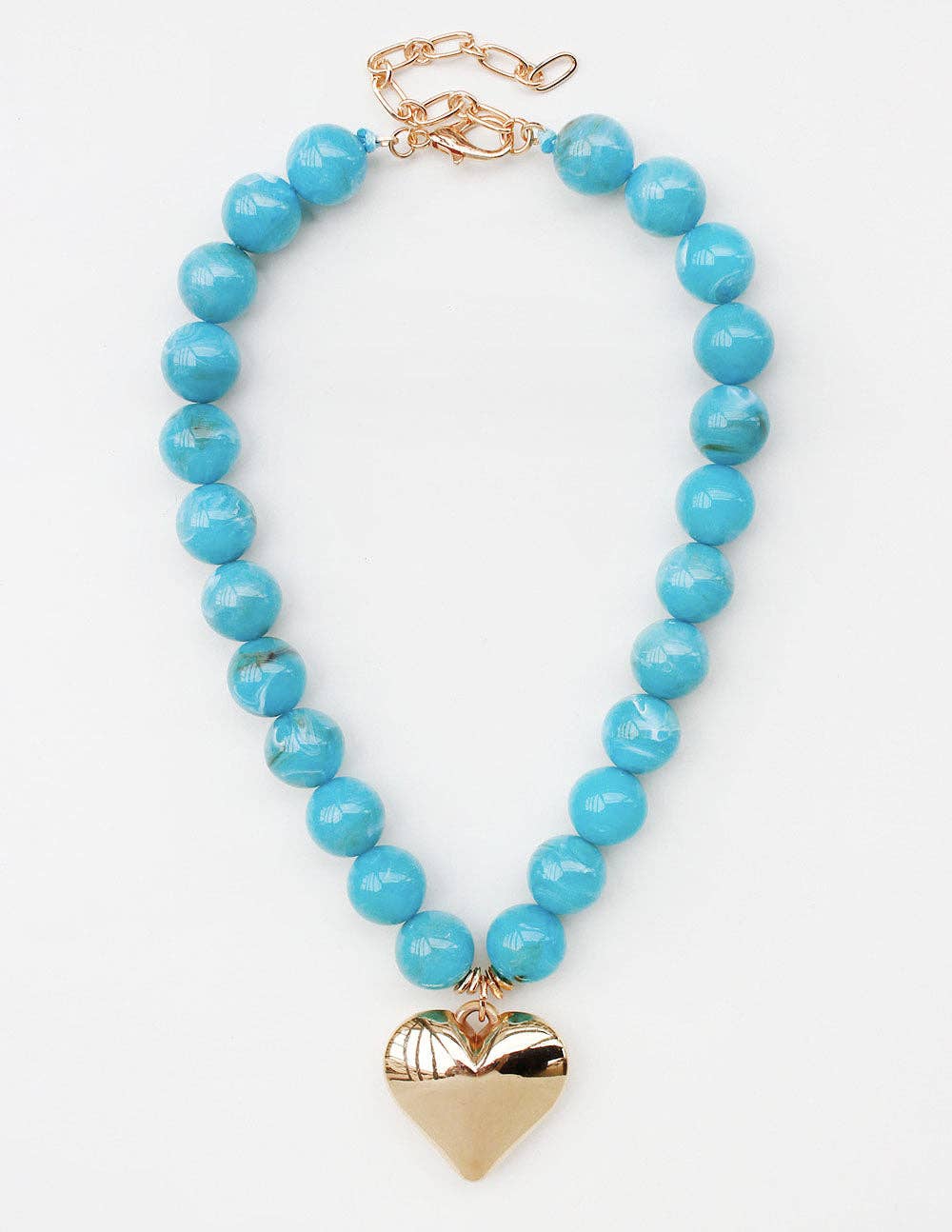 A turquoise blue beaded necklace with a polished gold heart pendant and gold clasp, displayed on a clean white background.
