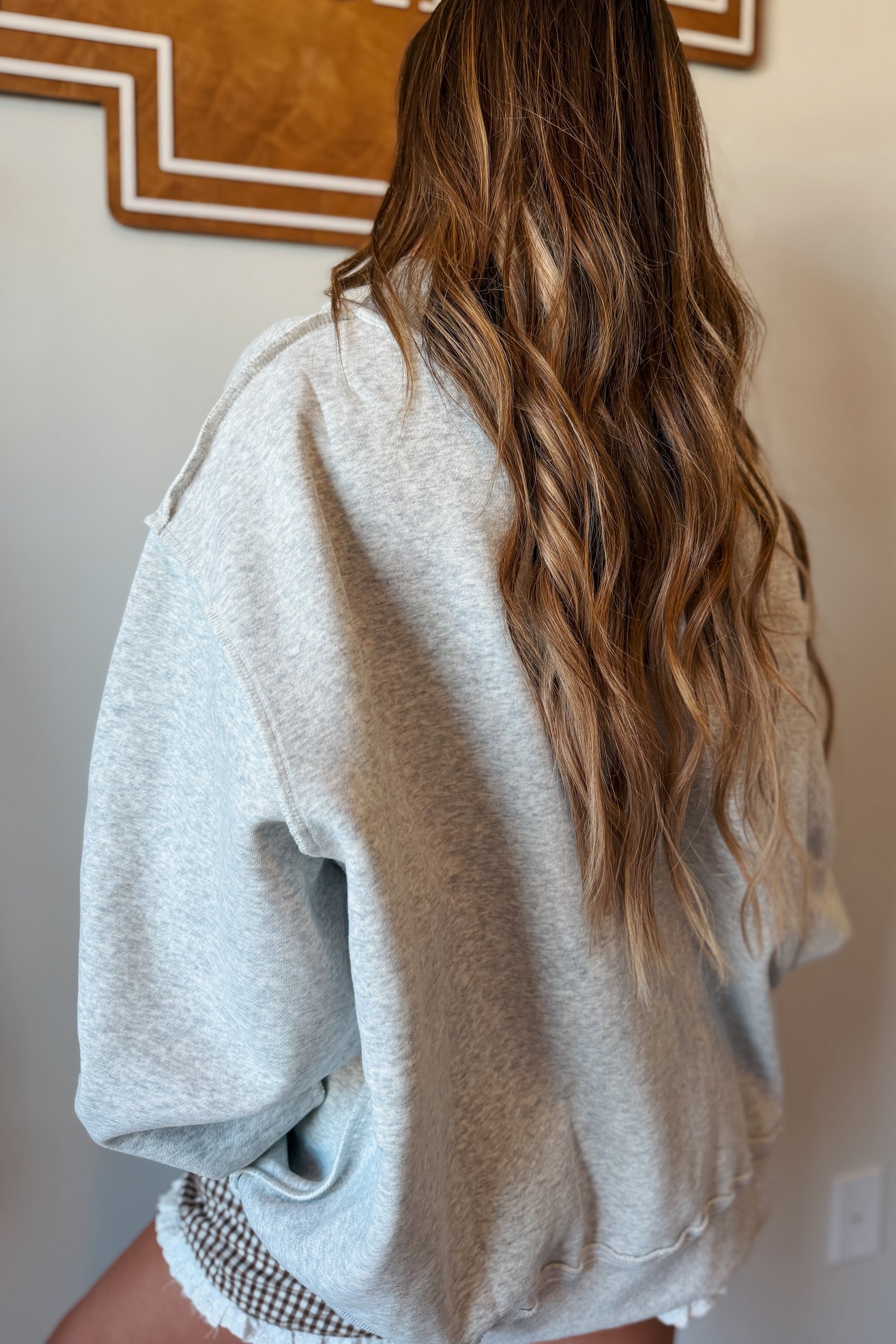 Back view of a brown mock neck sweatshirt with a relaxed silhouette, mock neckline, and comfortable everyday fit.
