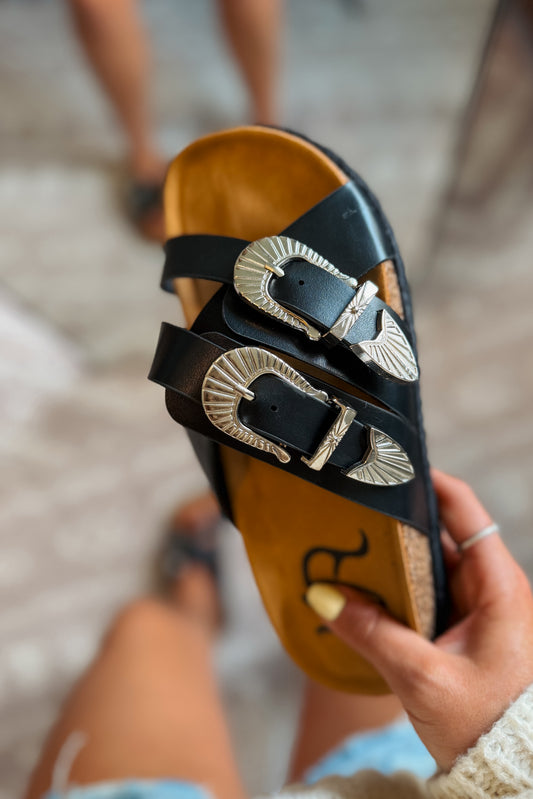 Black western slide sandals featuring buckle accents and a cushioned footbed