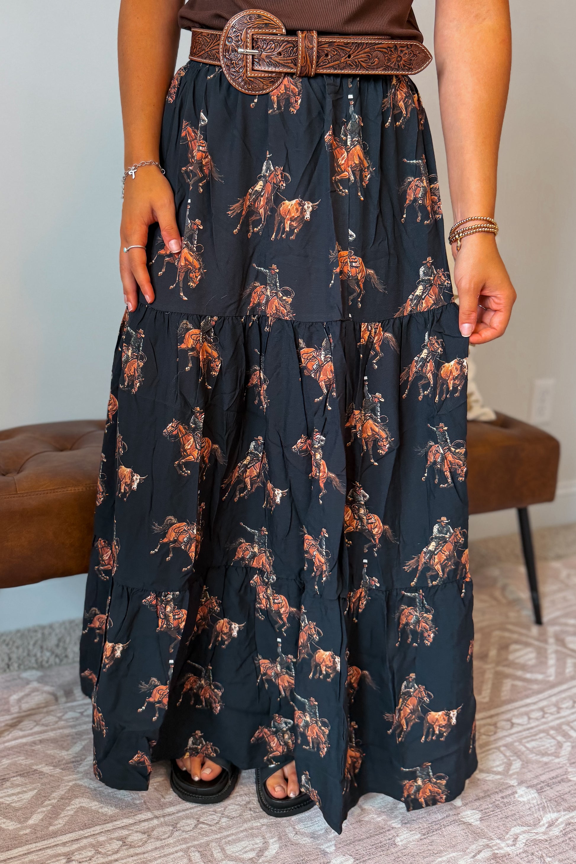 Black maxi skirt featuring an allover western horse print in a contrasting brown color. Designed with a comfortable elastic waistband and a flowy full-length silhouette.