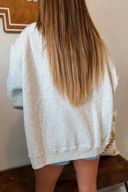 Back view of gray oversized western mock neck sweatshirt showing the relaxed fit.
