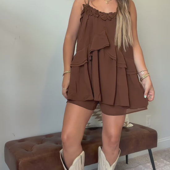 Video showing the fit, movement, adjustable tie straps, and flowy ruffle details of the brown romper.
