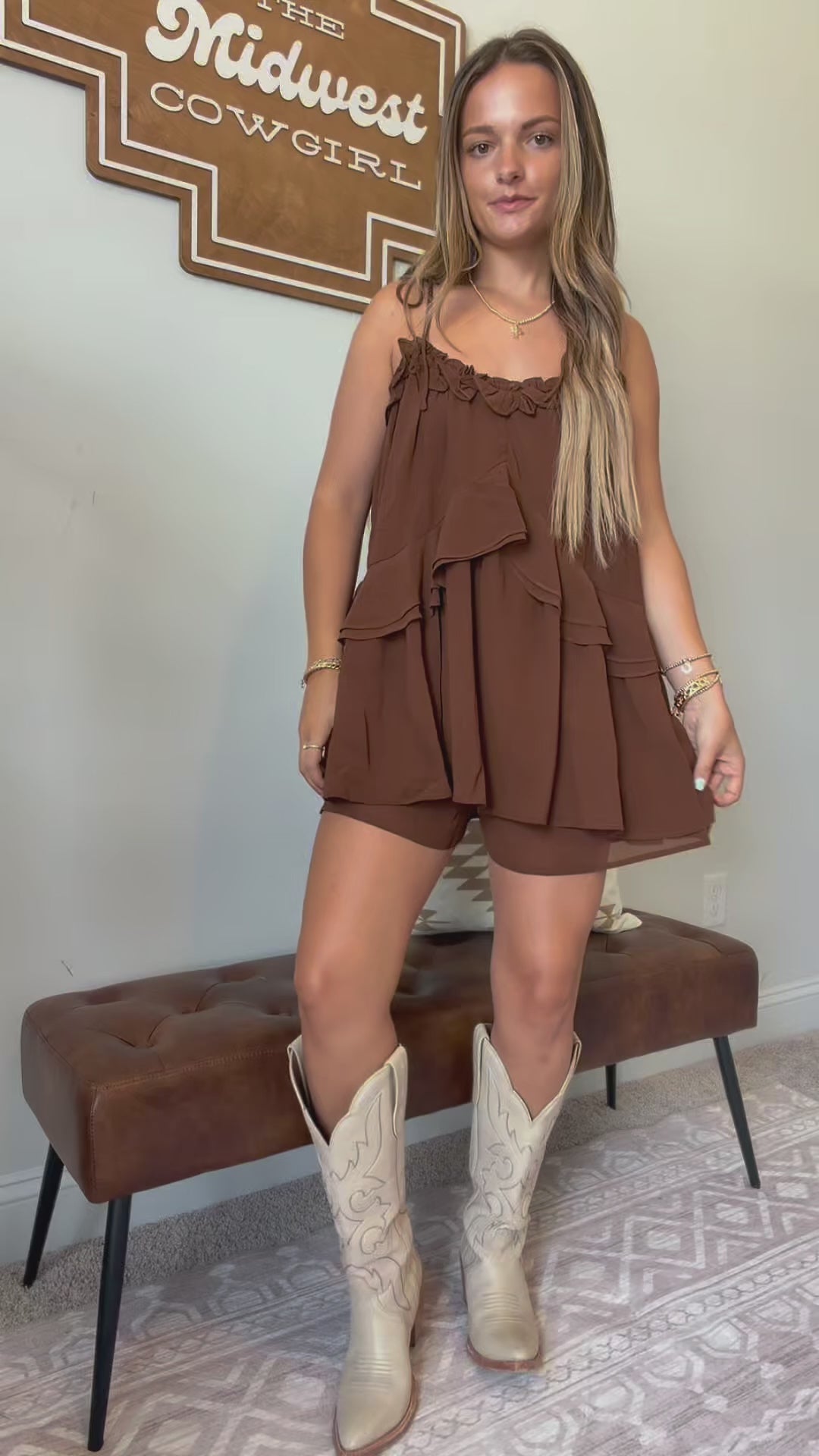 Video showing the fit, movement, adjustable tie straps, and flowy ruffle details of the brown romper.