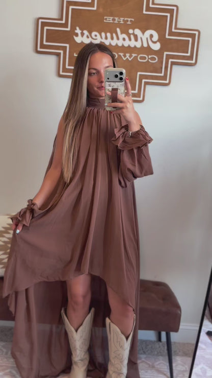 Video showing the fit, movement, halter neckline, and flowy high-low hemline of the brown maxi dress.

