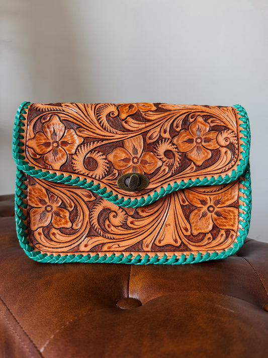 brown tooled leather back with teal stitching around boarder.
