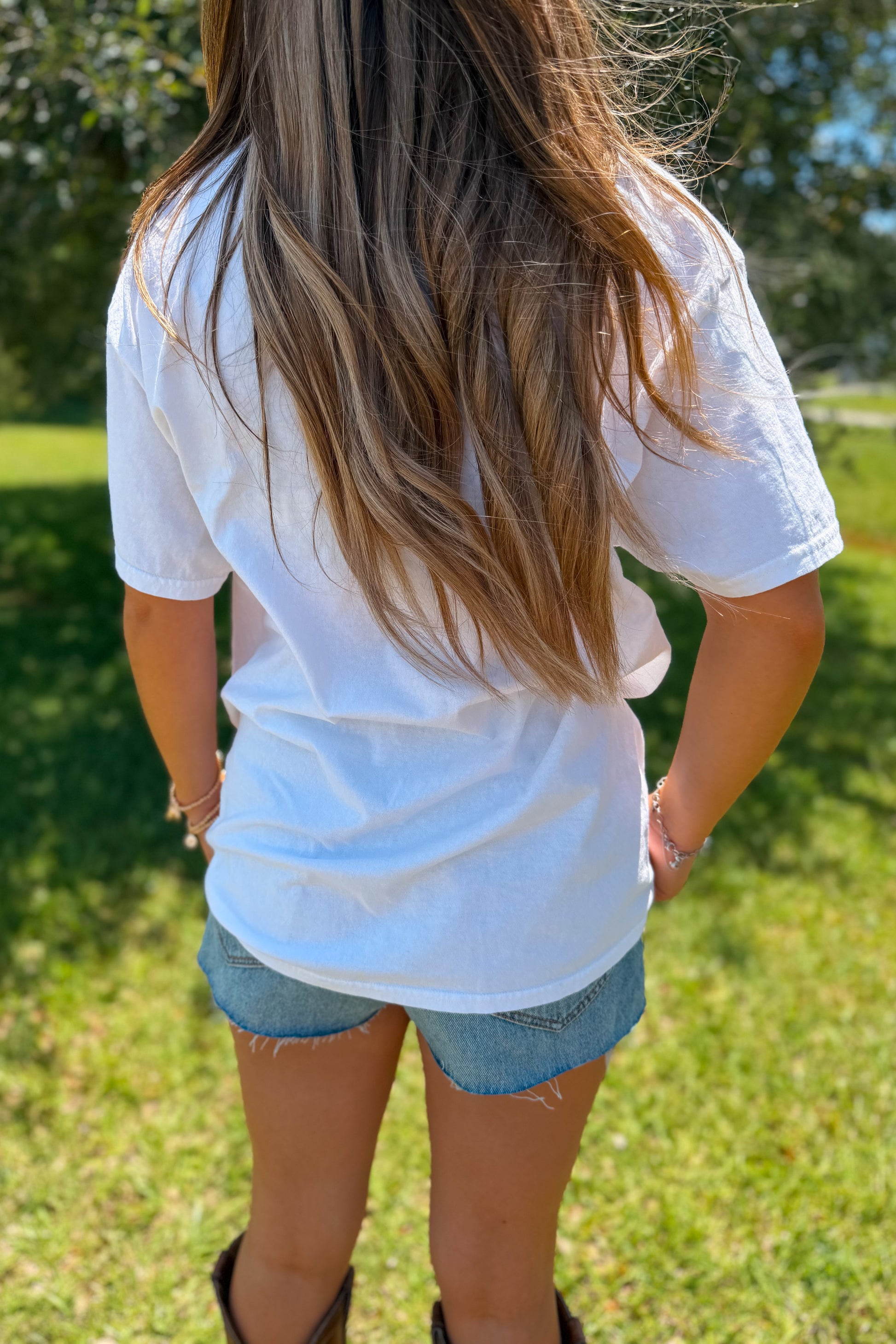Back view of white American graphic tee with relaxed fit.
